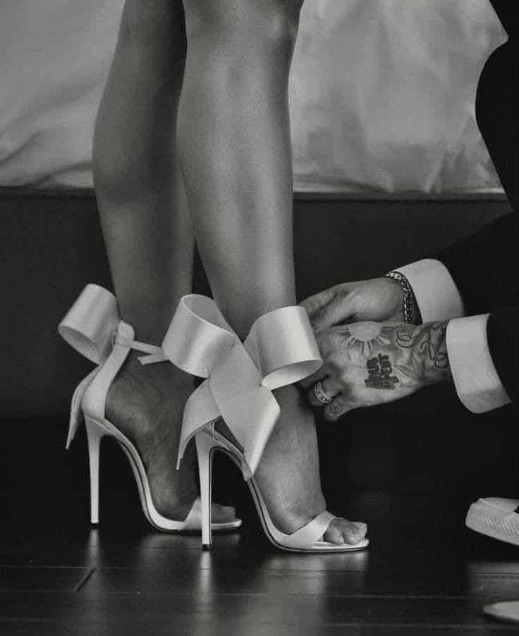 _ 39 Elegant high heels with bows being adjusted on a woman's feet, showcasing wedding or formal attire styling. | Sky Rye Design Elegant high heels with bows being adjusted on a woman's feet, showcasing wedding or formal attire styling.