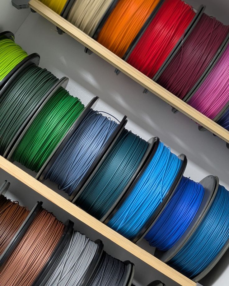 3D Printing Filament Eco-friendly materials Sustainable 3D printing PLA filament Filament colors Multicolored spools of 3D printer filament neatly arranged on shelves. | Sky Rye Design Multicolored spools of 3D printer filament neatly arranged on shelves.