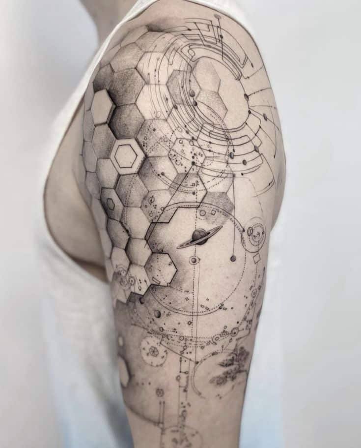 Geometric space-themed tattoo on upper arm featuring hexagons, circuits, and a planet with rings.