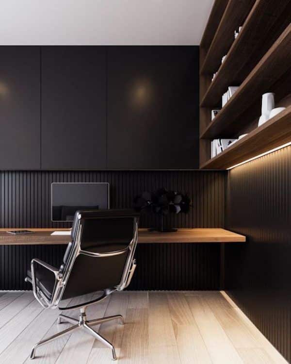 Minimalist black home office with modern desk, shelving, and ergonomic chair.