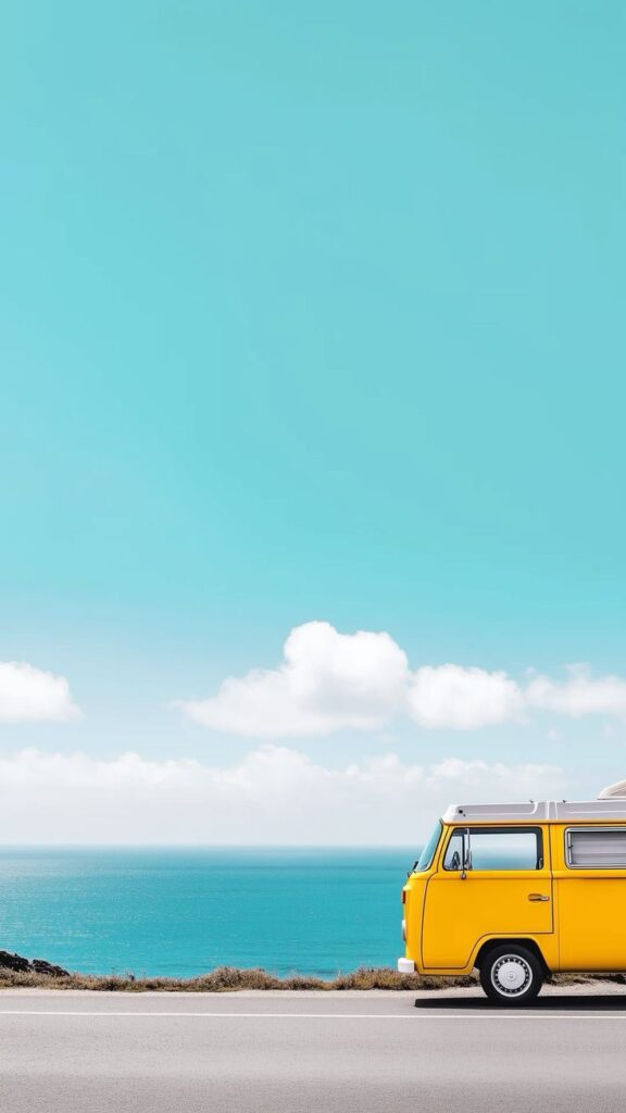 Yellow van on a coastal road with blue sky and ocean background. Ideal for summer travel inspiration.
