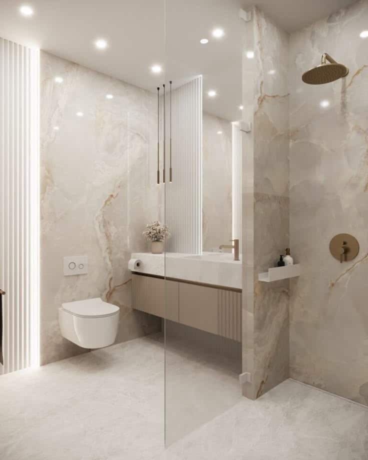 Luxurious marble bathroom featuring modern fixtures, wall-mounted toilet, and a sleek glass shower for a stylish look.