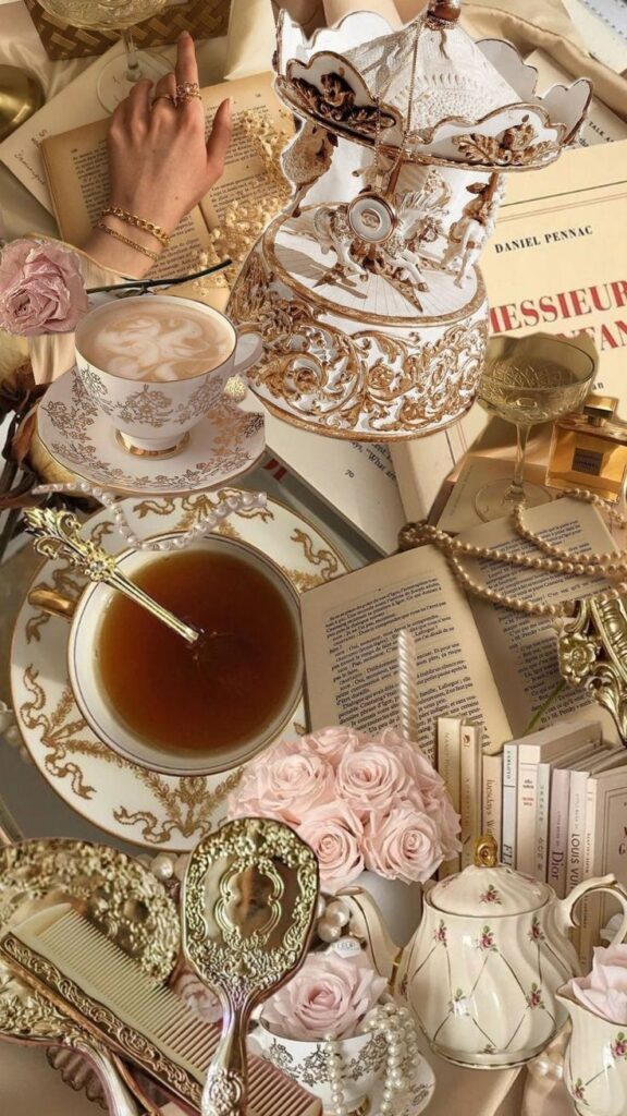 Elegant vintage tea set and books with roses, pearls, and carousel decor in a luxurious, gold and white theme.