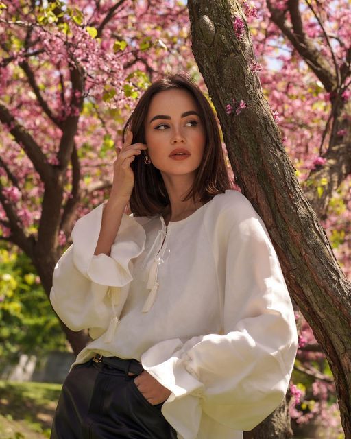 4974ab40-a8b6-402c-b18c-58c90ce448c3 Woman in white blouse posing under blooming cherry blossom trees in a park. Natural beauty and spring vibes. | Sky Rye Design Woman in white blouse posing under blooming cherry blossom trees in a park. Natural beauty and spring vibes.