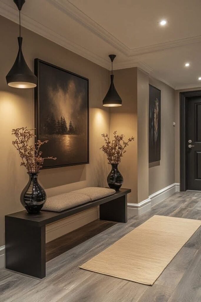 Modern hallway with bench, plants, pendant lights, and art, creating a warm, inviting atmosphere.