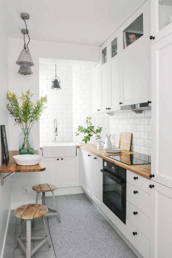 4e6813ad963c75ff98218307650fd8c2 Modern white kitchen with wooden countertops, stylish stools, and pendant lighting for a cozy vibe. | Sky Rye Design Modern white kitchen with wooden countertops, stylish stools, and pendant lighting for a cozy vibe.