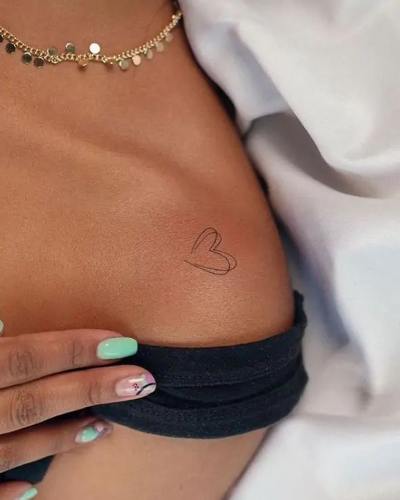 54 Gorgeous Shoulder Tattoos For Women Minimalist heart tattoo on ribcage with aqua manicure and gold necklace detailing. | Sky Rye Design Minimalist heart tattoo on ribcage with aqua manicure and gold necklace detailing.