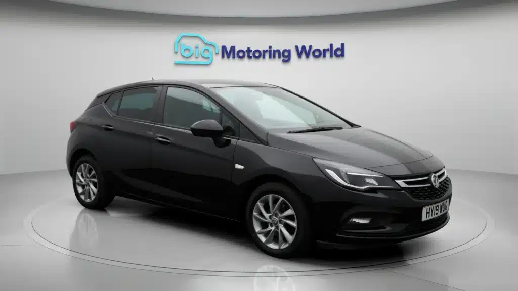 Black hatchback car in showroom setting at Big Motoring World, side view.