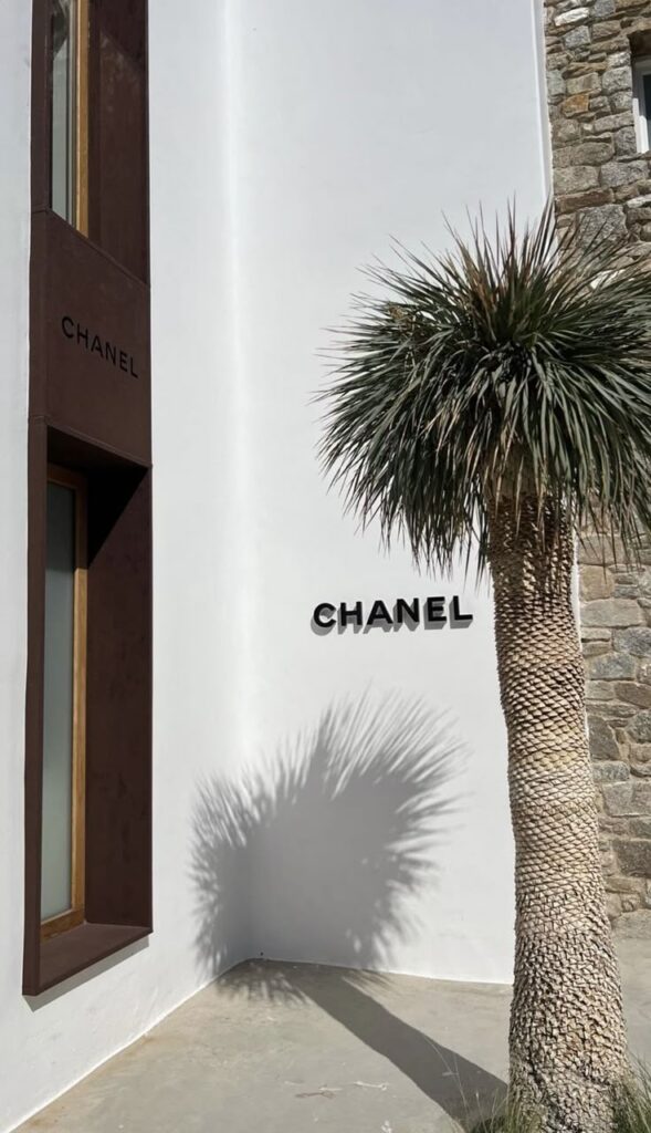 Chanel building exterior with palm tree shadow on a sunny day. Fashion brand store entrance.
