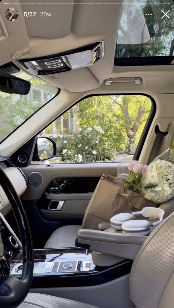 86ffdda0-634c-4160-805c-e20471a6a904 Car interior with flowers on passenger seat, sunny day outside. | Sky Rye Design Car interior with flowers on passenger seat, sunny day outside.