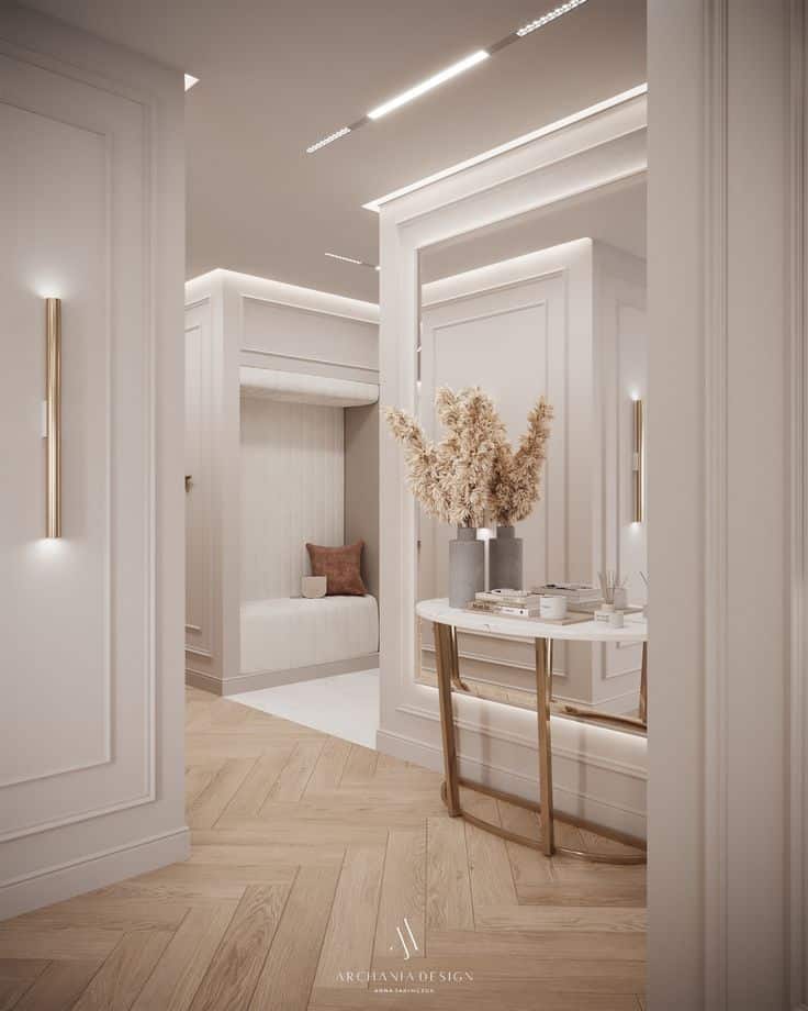 Elegant hallway interior with modern decor, soft lighting, and a round table with a centerpiece vase and books.