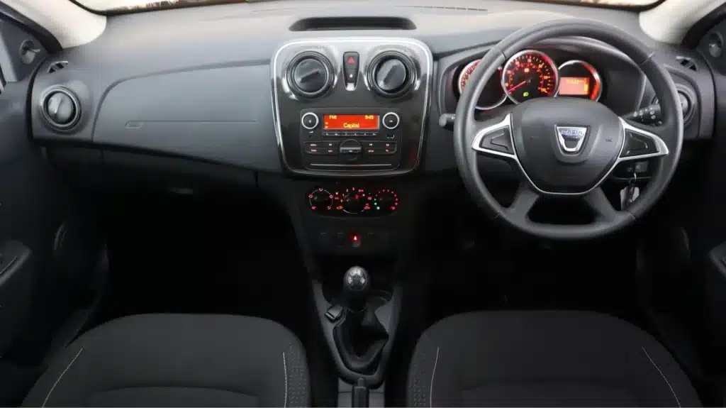 Car interior featuring dashboard, steering wheel, and manual gear shift, showcasing modern vehicle design.