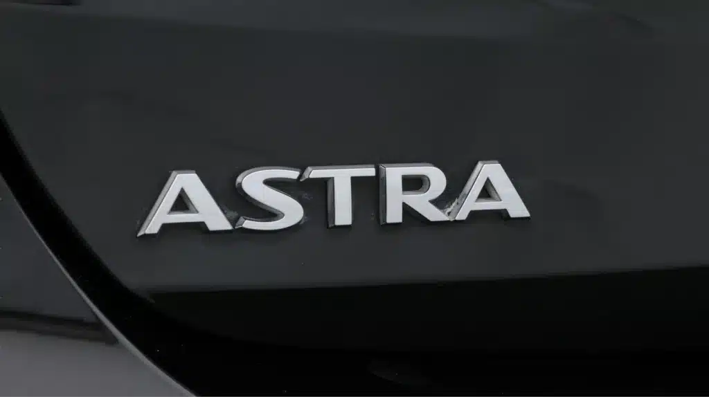Close-up of Astra car logo on a sleek black vehicle surface.
