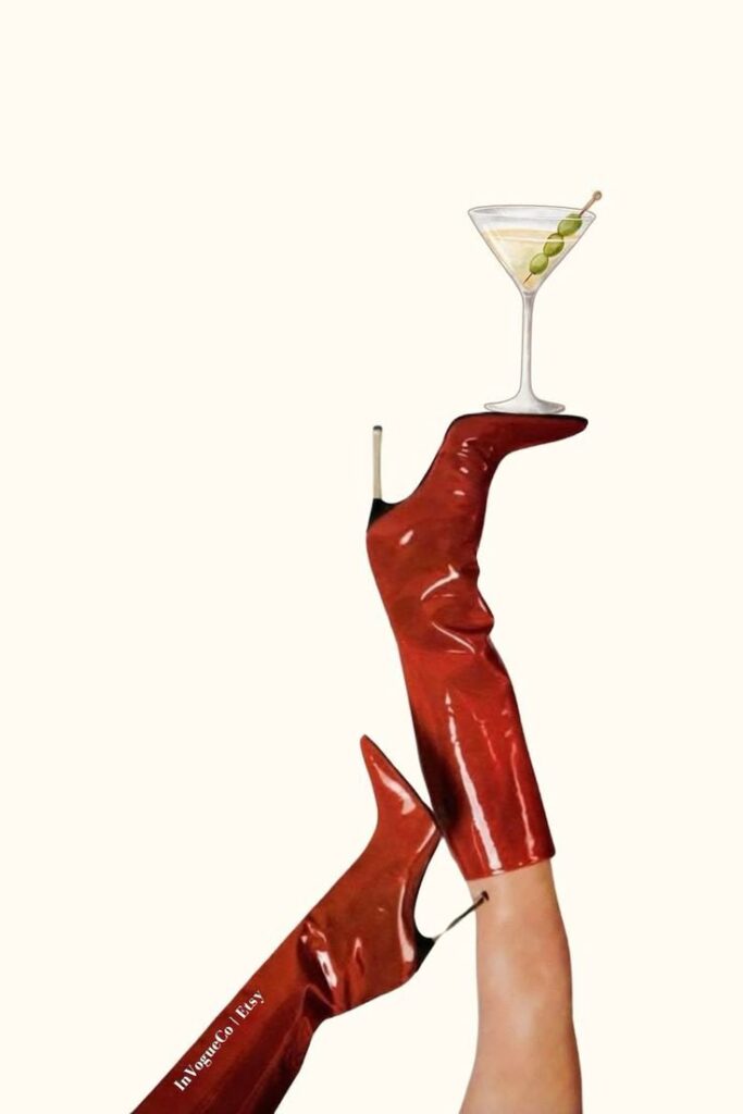 Red high heels with a cocktail glass balanced on the foot, showcasing style and elegance on a white background.