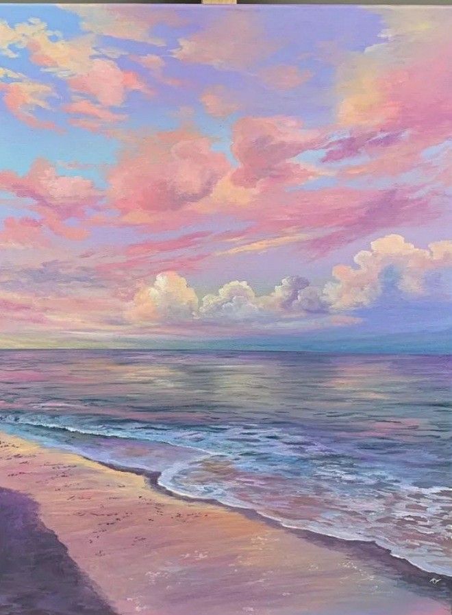 Colorful beach sunset with pink clouds reflected on tranquil ocean waves and sandy shore.