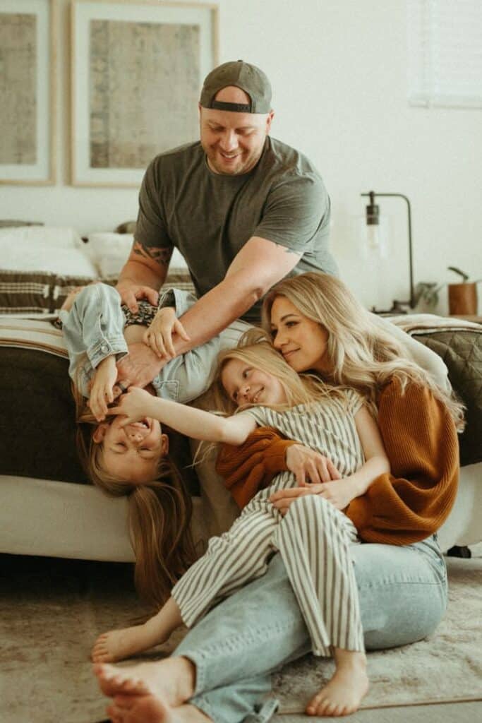 Happy family playing and laughing together in a cozy living room setting, enjoying quality time.