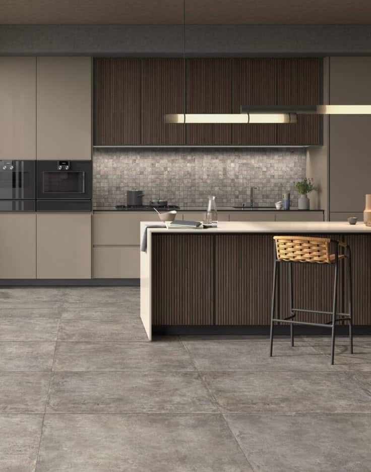 Modern kitchen with sleek cabinets and island, featuring a tiled backsplash and contemporary lighting.