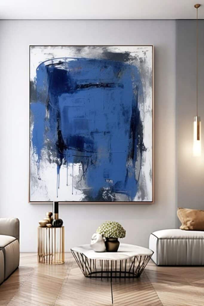 Large blue abstract painting in modern living room with stylish furniture and decor elements.