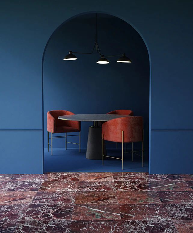 Modern dining room with blue walls, red chairs, round table, and marble floor.