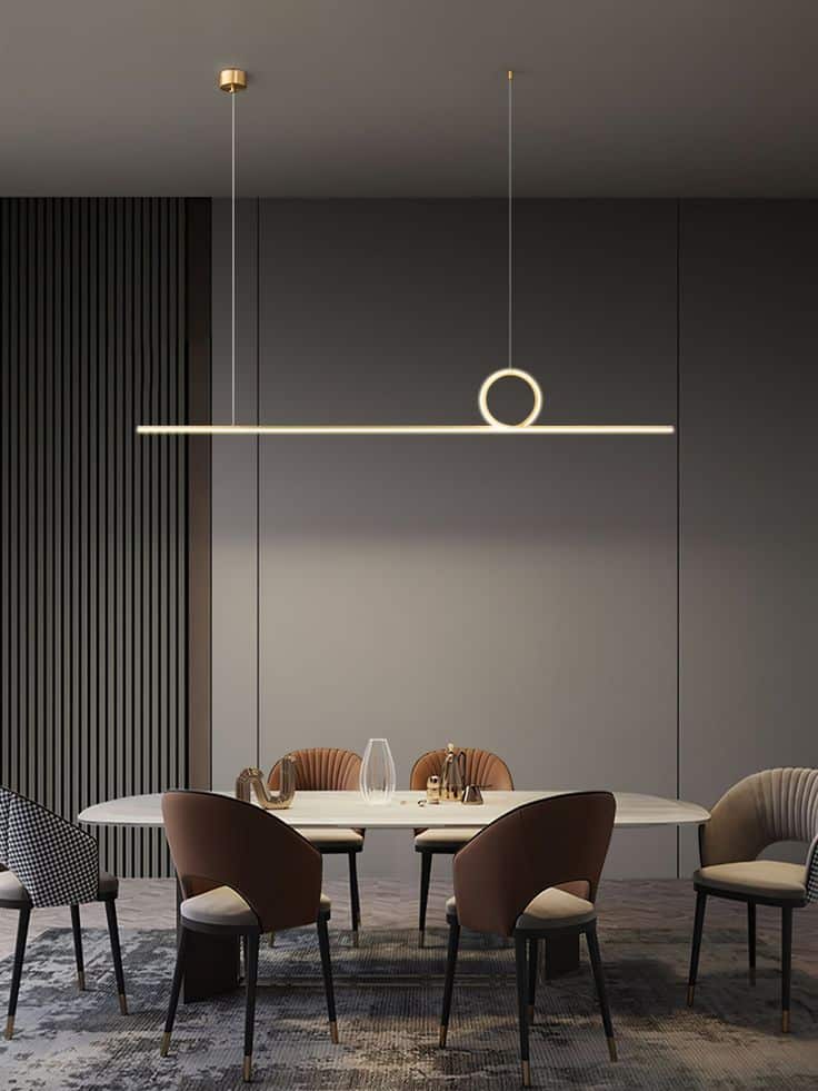 Modern dining room with sleek pendant light over table, surrounded by stylish chairs and minimalist decor.