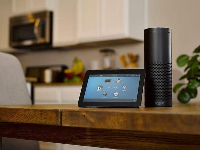 Smart home setup with tablet and speaker on kitchen table, showcasing connected devices for modern living.