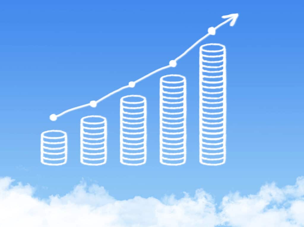 Graph of increasing growth or success, represented by cloud-like bars and an upward arrow against a blue sky.