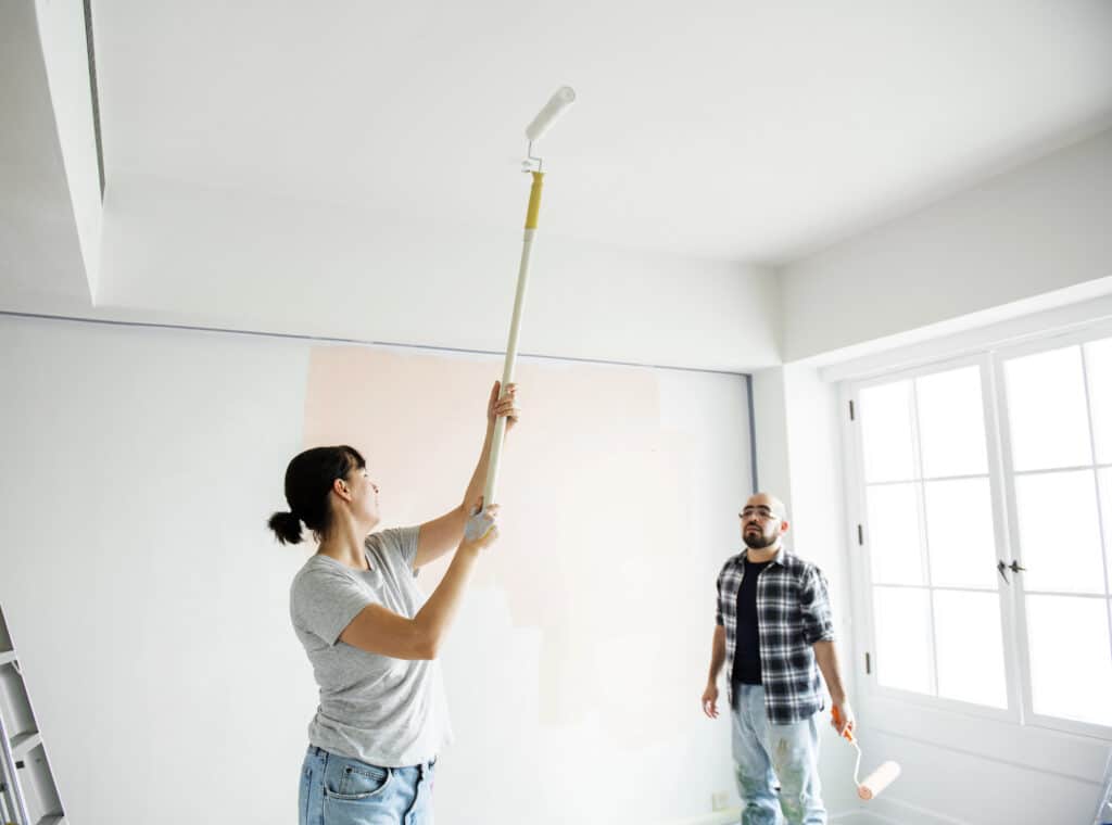 Depositphotos_194298368_XL Couple painting a wall white with rollers in a bright room, home renovation project. | Sky Rye Design Couple painting a wall white with rollers in a bright room, home renovation project.