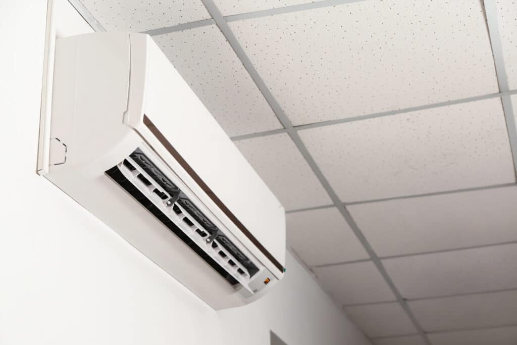 Wall-mounted air conditioner on a white ceiling, providing climate control and efficient cooling.