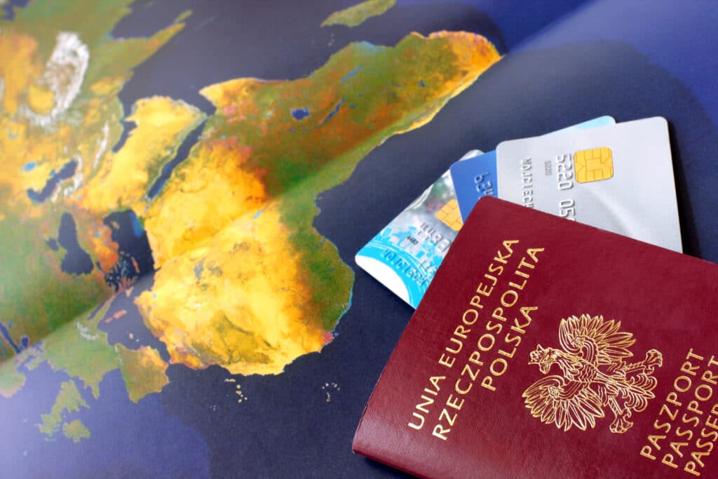 Depositphotos_2927916_XL Polish passport and credit cards on a colorful world map, symbolizing travel and global finance. | Sky Rye Design Polish passport and credit cards on a colorful world map, symbolizing travel and global finance.