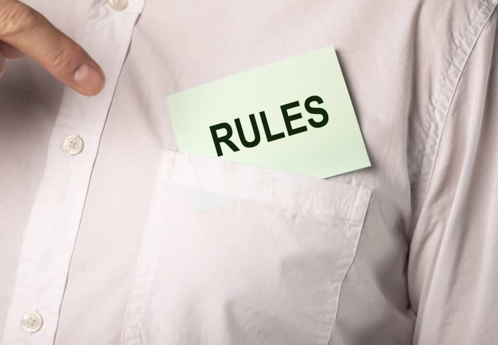 Close-up of a person pointing to a pocket with a card labeled RULES inside.
