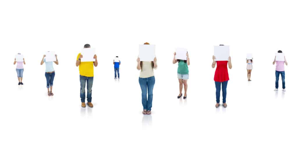 Seven people holding blank signs stand against a white background, conveying anonymity and individuality.