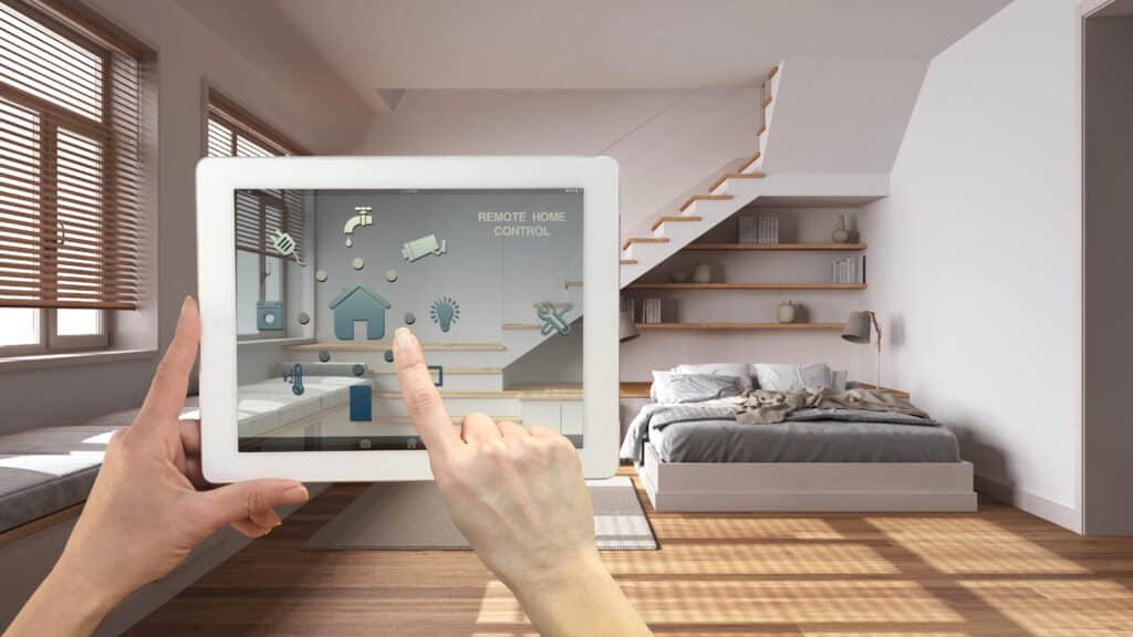 Person using tablet to control smart home devices in modern bedroom.