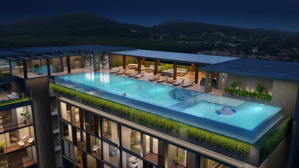 Luxurious rooftop infinity pool at night, with lounge chairs and mountain views.