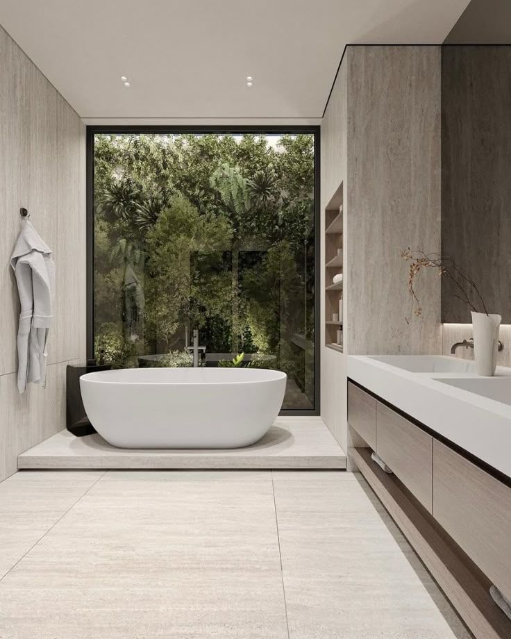 Modern bathroom with freestanding tub and large window overlooking lush greenery, creating a serene and luxurious ambiance.