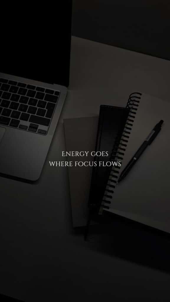 Laptop and notebooks on a desk with quote: Energy goes where focus flows.