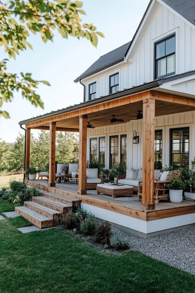 Cozy farmhouse porch with wooden beams, outdoor seating, and lush garden, under a clear sky.
