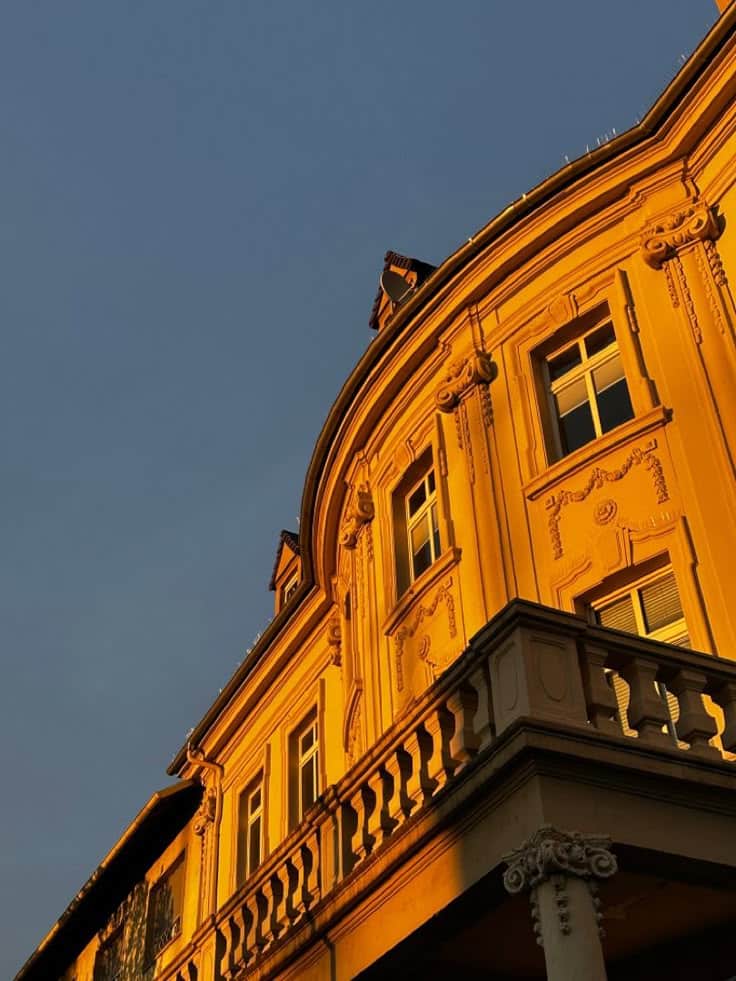 Ornate historic building facade glowing in warm sunset light against a clear sky.