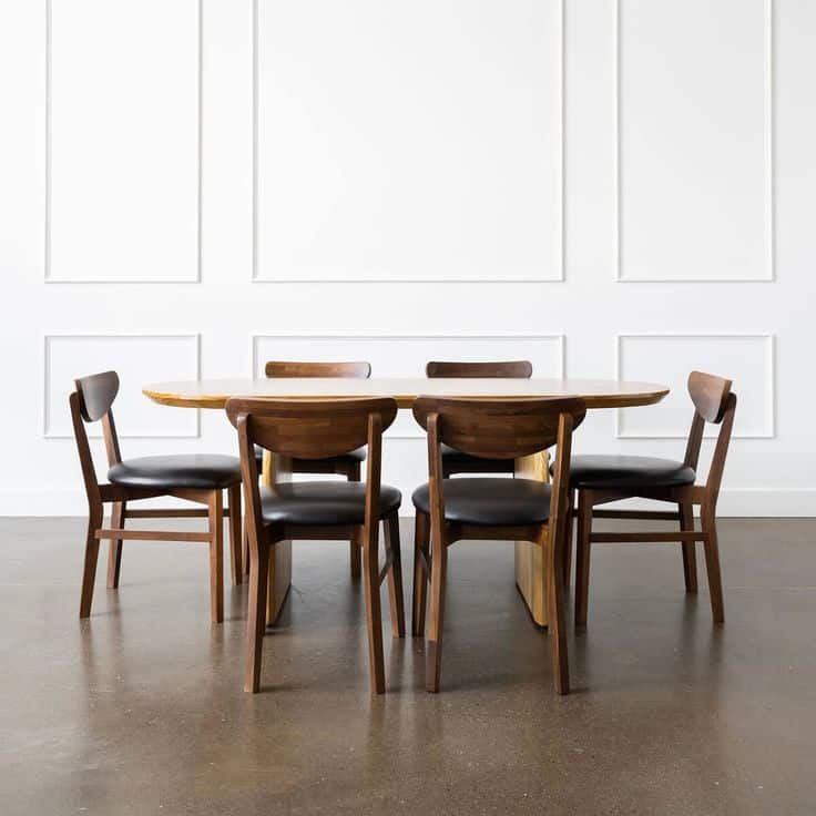 Elegant wooden dining table with six chairs set against a minimalistic white wall for a modern interior design.