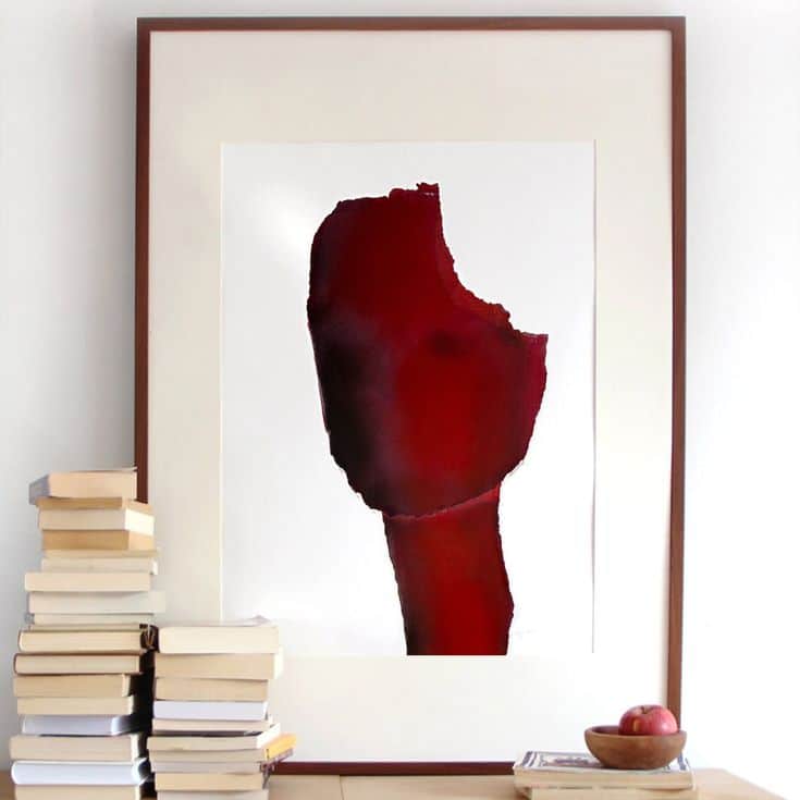 Framed abstract red painting with stacked books and apples on the side, minimalist decor.