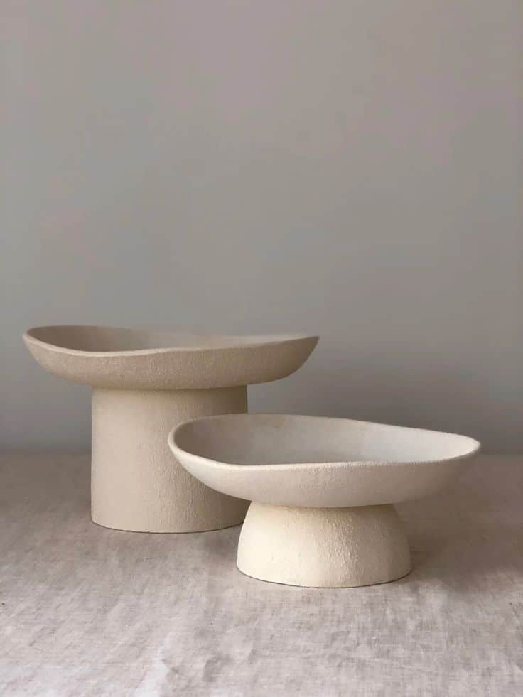 Minimalist beige ceramic bowls on a neutral background, showcasing modern home decor aesthetics.