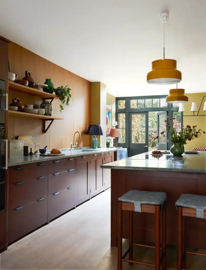 Contemporary kitchen with wooden cabinets, marble countertops, pendant lights, and large windows overlooking a garden.