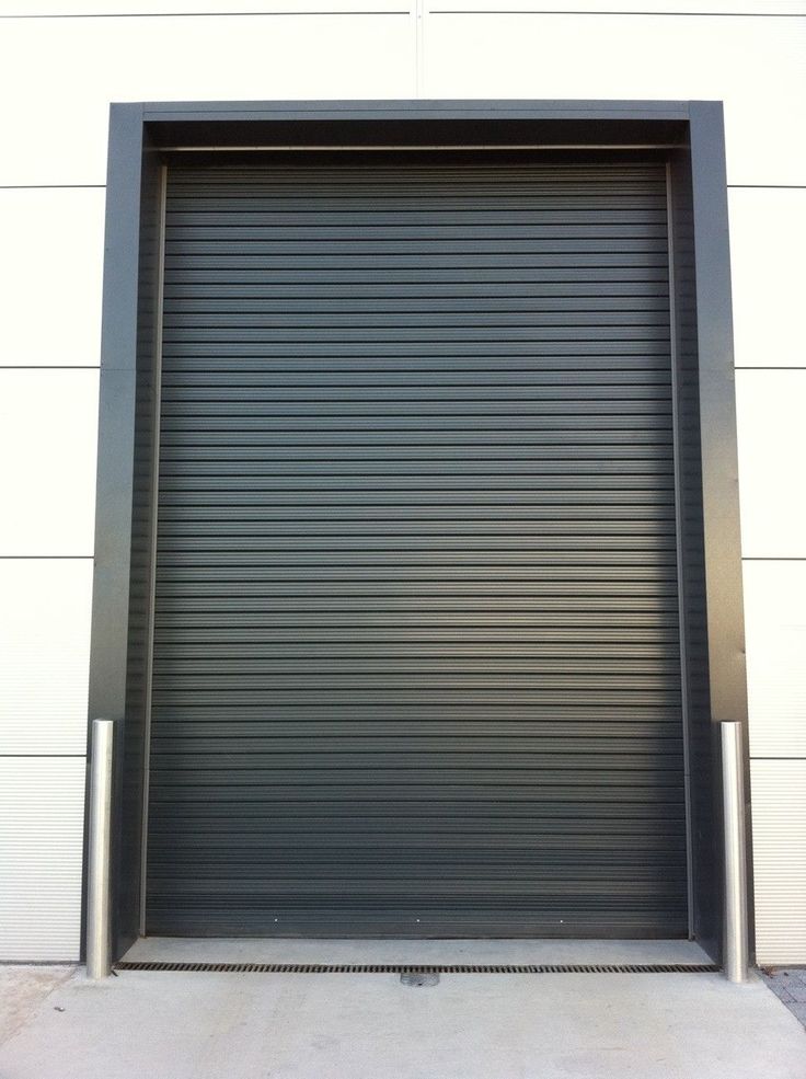 Steel industrial roller door closed in a modern warehouse setting.