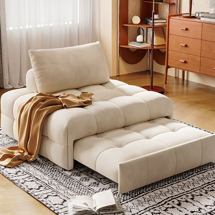 Cream chaise lounge on patterned rug in cozy living room with natural light and wooden accents.