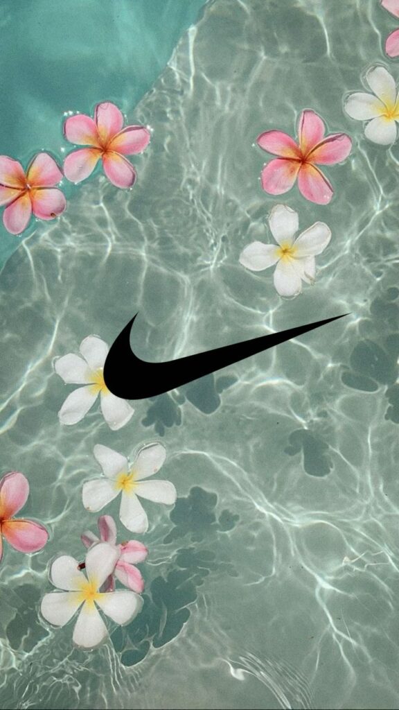 Floating tropical flowers and swoosh logo on clear water surface.