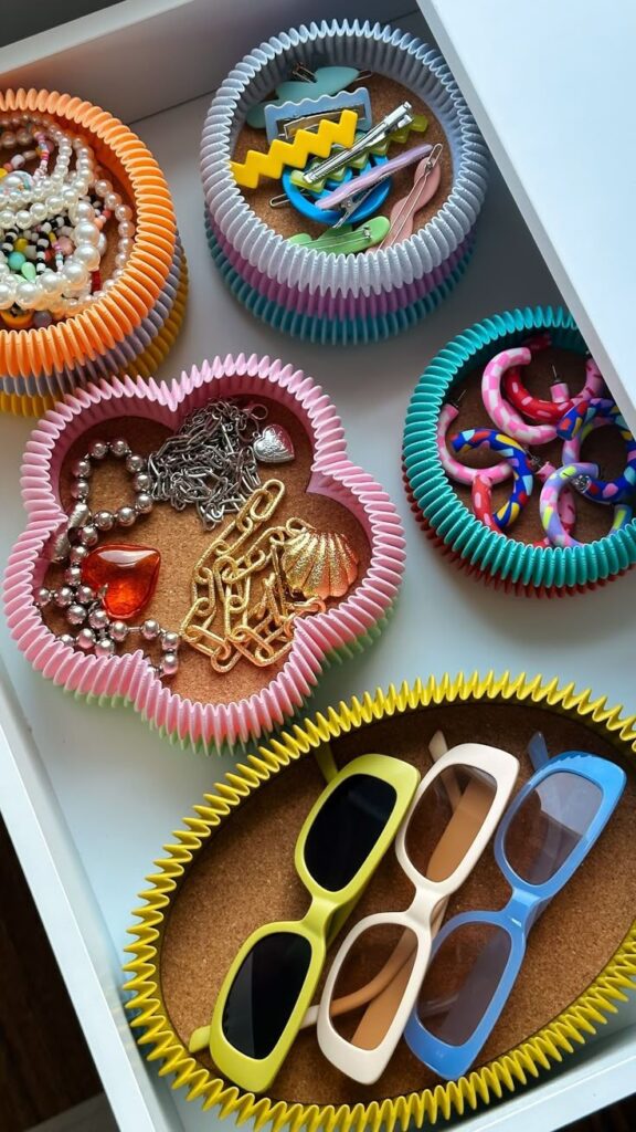 Colorful containers organizing jewelry and sunglasses in a drawer for efficient storage.
