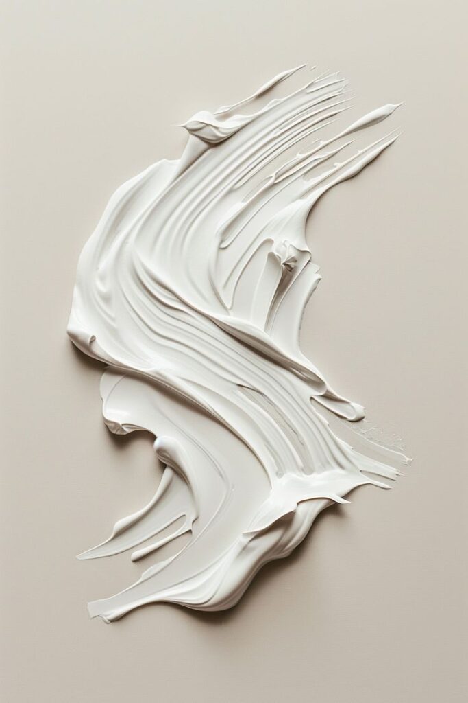 Smooth white cream swirled on a neutral background, showcasing texture and elegance. Ideal for skincare or beauty themes.