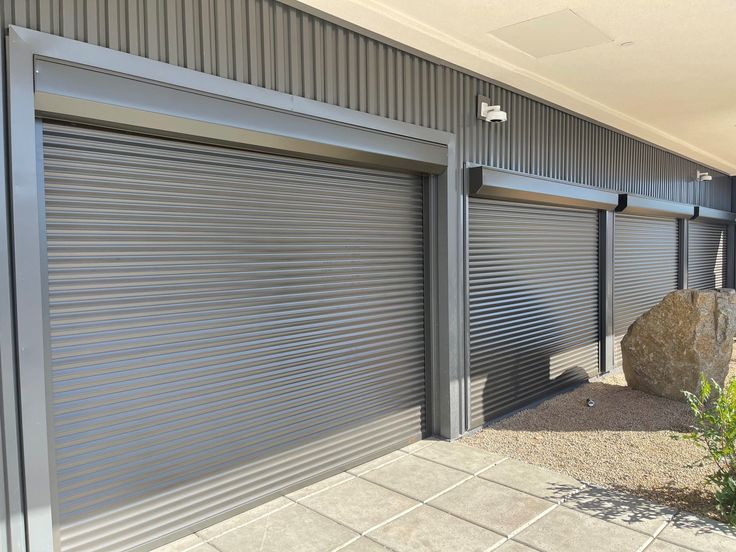 Modern grey metal roller garage doors in industrial setting, enhanced security.