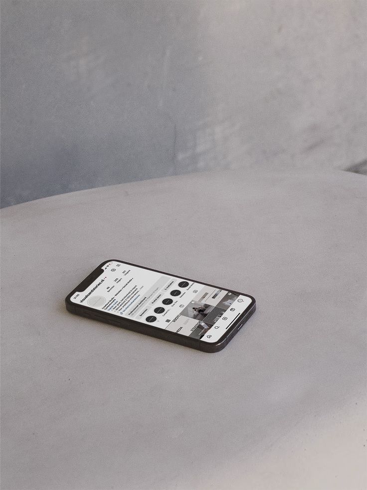 Smartphone on a table displaying social media profile in a minimalist setting, emphasizing digital connectivity.
