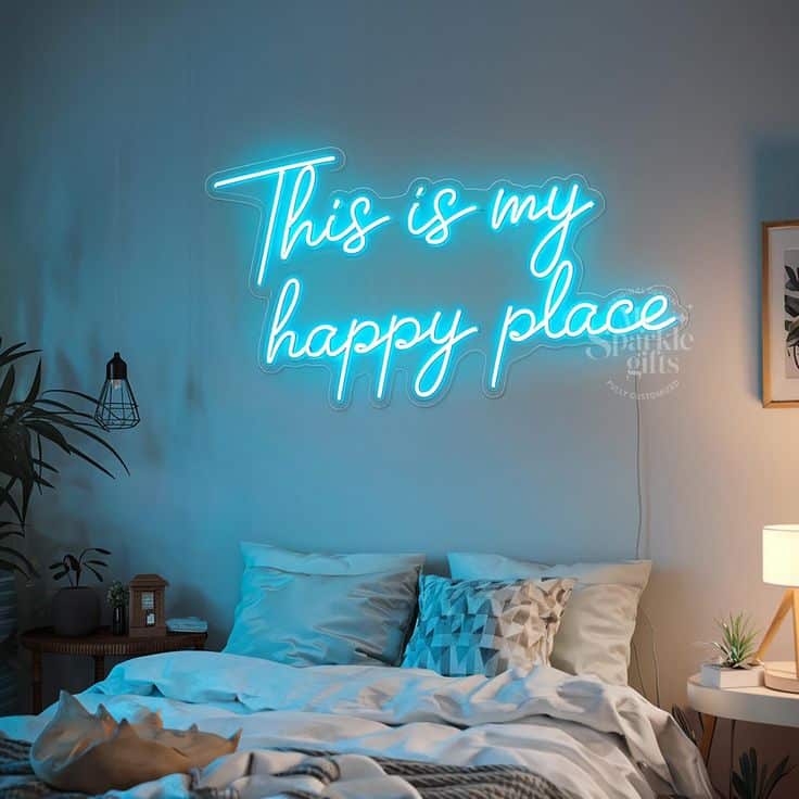 Cozy bedroom with This is my happy place neon sign, pillows, plants, and soft lighting for a relaxing ambiance.