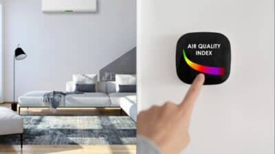 Modern living room with air conditioning unit and hand interacting with air quality index device on wall.